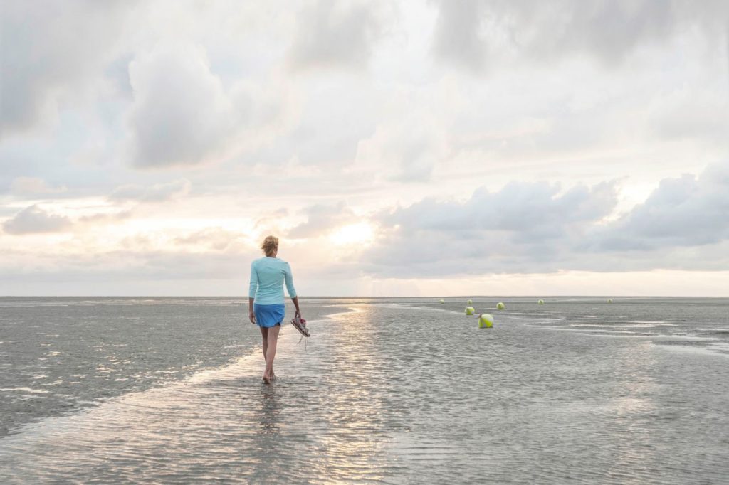 Spaziergängerin am Strand von St. Peter-Ording