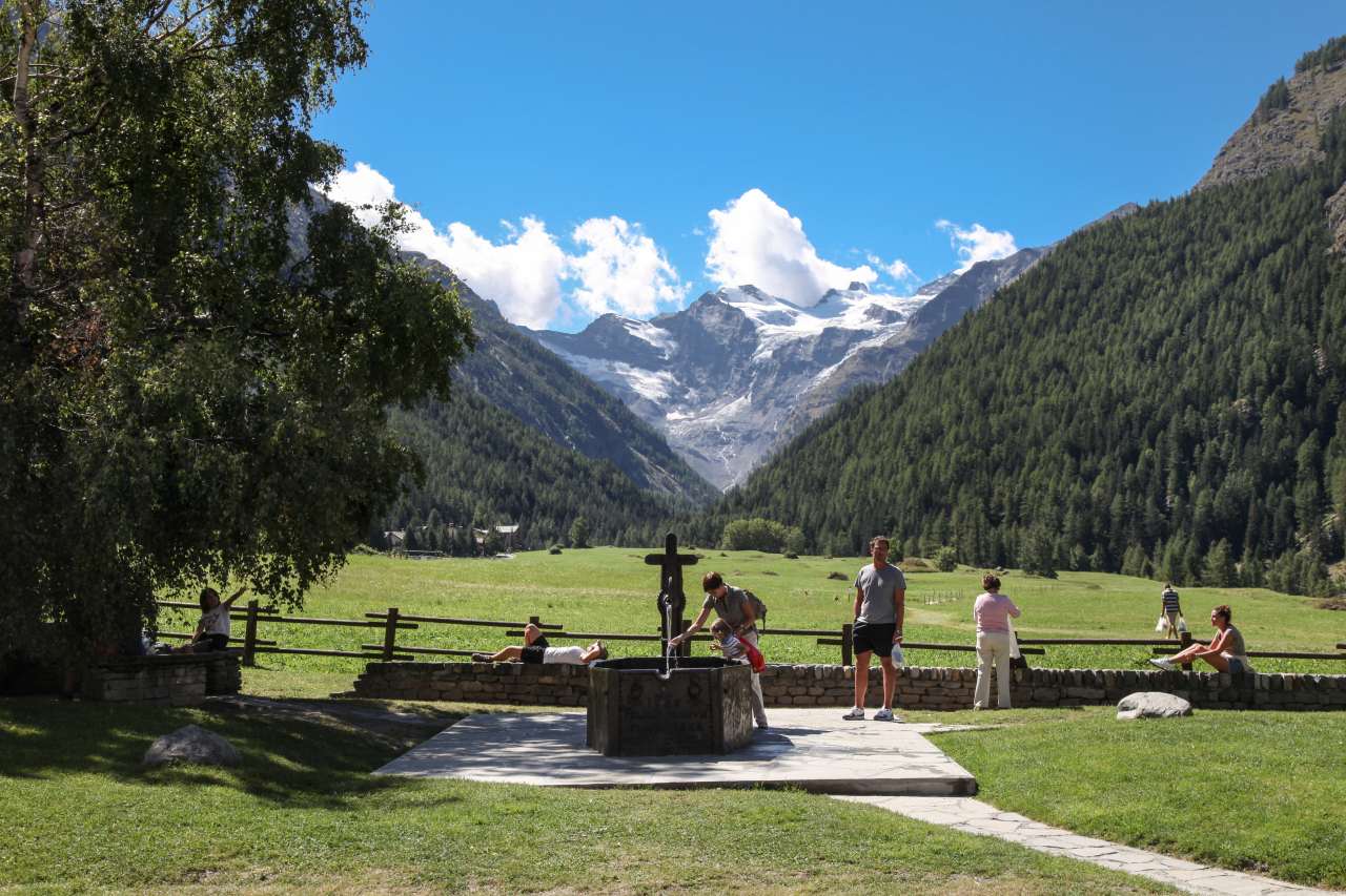 Wanderpause Familie Aostatal am Brunnen