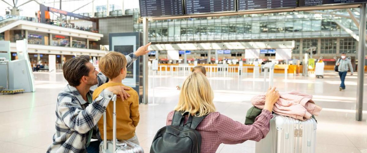 Familie vor Anzeigentafel Flughafen Hamburg