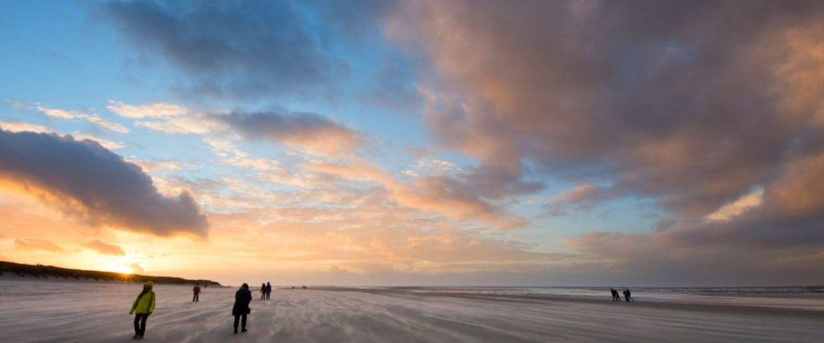 Spaziergänger im Herbstwind am Strand von Langeoog