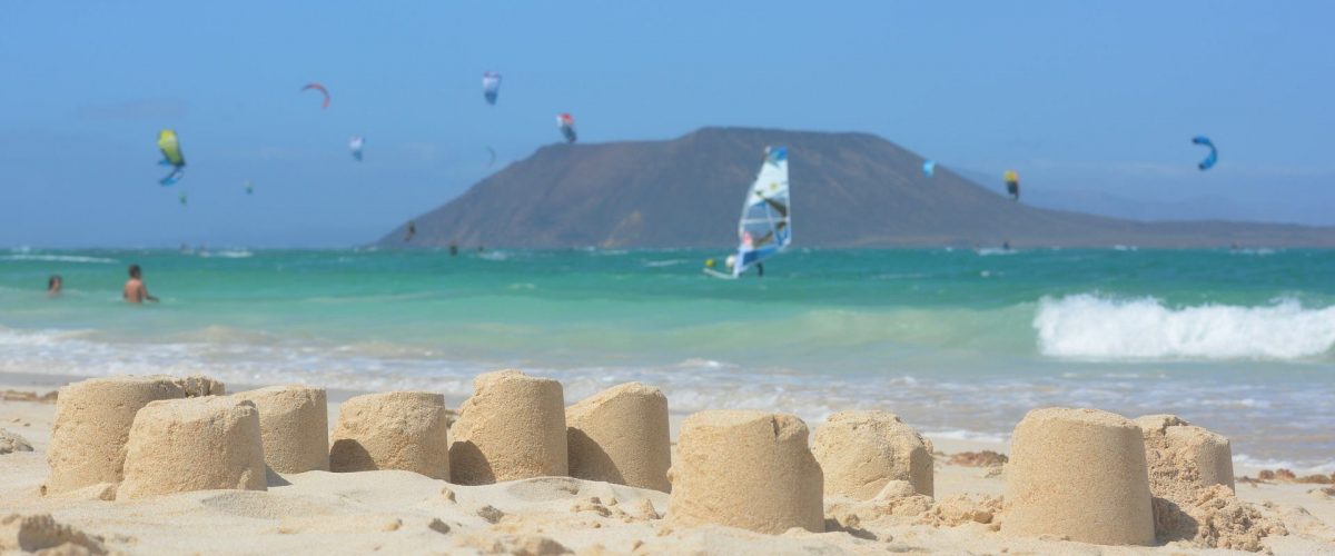 Strand von Corralejo mit Sandburgen und Insel Los Lobos